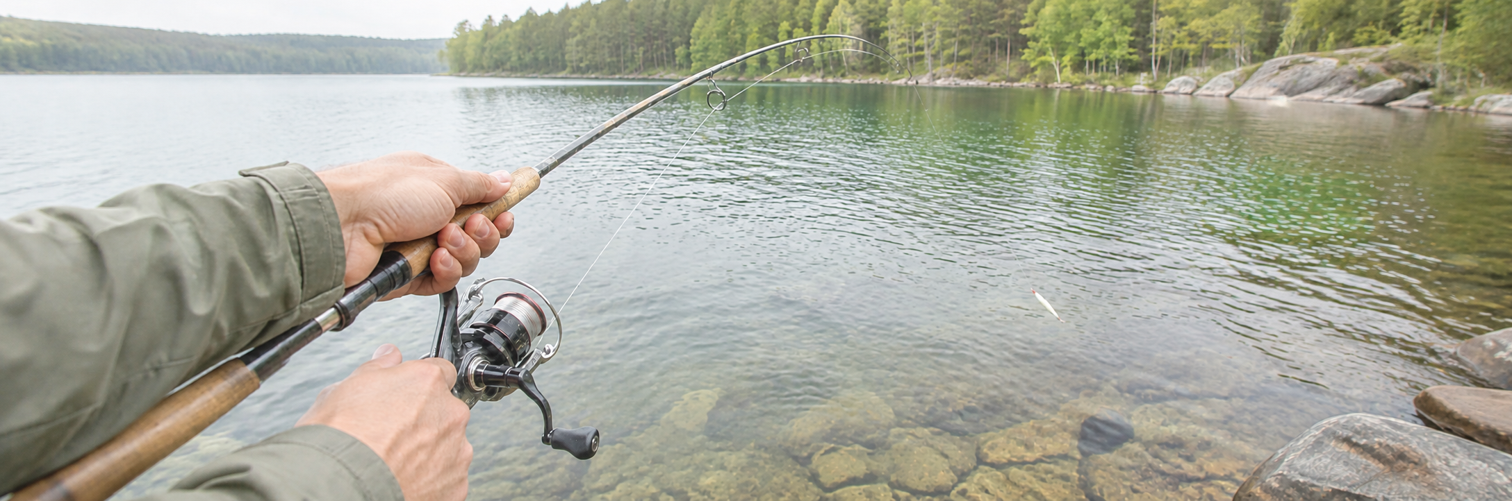 Spinnfischer mit Gummifisch am See